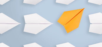 Change concepts with orange paper airplane leading among white